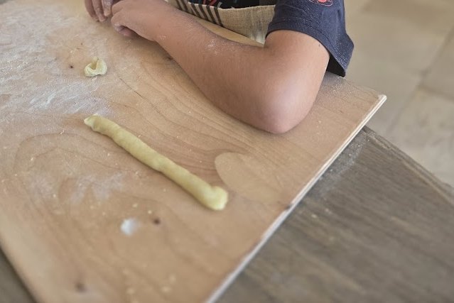 Hands rolling orecchiette at a long table, a Pugliese pasta morning at Casa Andrea.